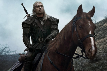 Henry Cavill rides a horse in the show The Witcher.